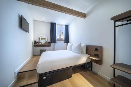 sypialnia z białym łóżkiem i oknem w obiekcie Hotel Nes Amsterdam w Amsterdamie