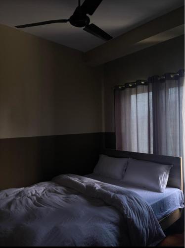 a bedroom with a bed with a ceiling fan at Hotel Lake Heaven in Deorāli