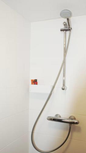 a shower with a hose attached to a wall at Sotto Terra in Katwijk aan Zee