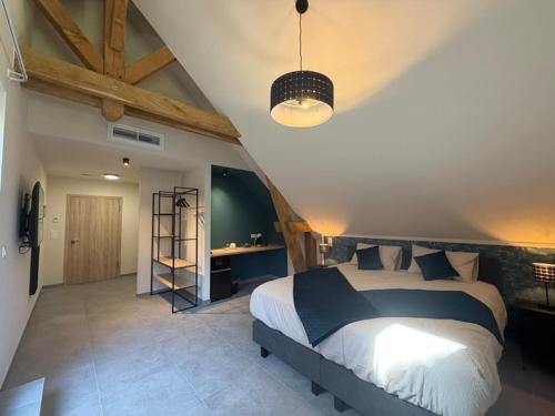 a bedroom with a large bed in a room at Le Fourquet Blaugies - Hôtel & restaurant in Dour