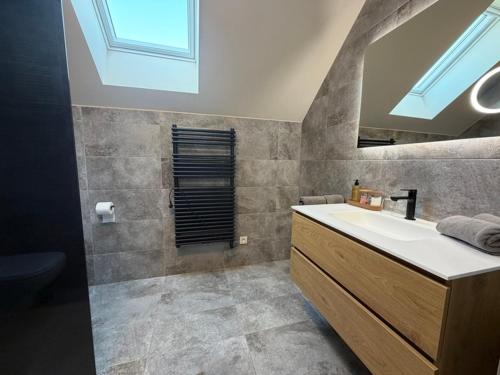 a bathroom with a sink and a mirror at Le Fourquet Blaugies - Hôtel & restaurant in Dour