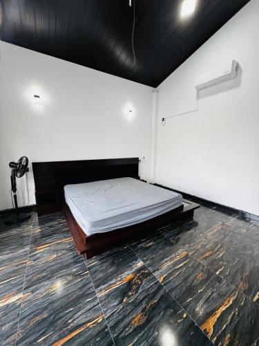 a bedroom with a bed in the middle of a room at 22 apartments in Kalapaluwawa
