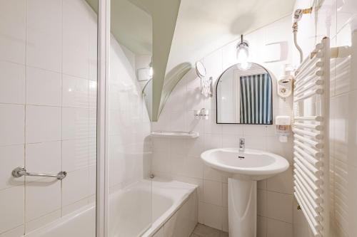 a white bathroom with a sink and a shower at Giselle Buda Castle in Budapest