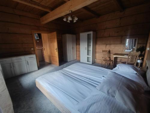 a bedroom with a large bed in a wooden room at Schronisko Stary Młyn in Zakopane