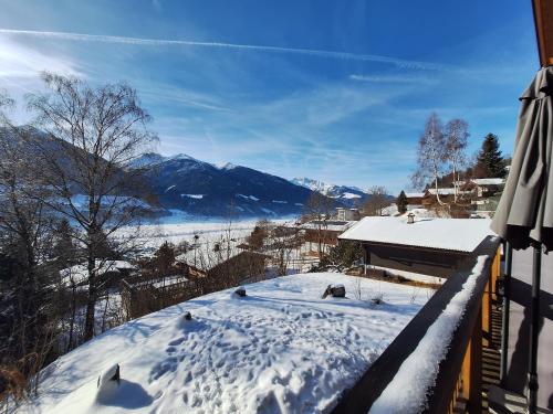 a snow covered balcony with a view of a mountain at Chalet Dinkel in Niedernsill in Niedernsill