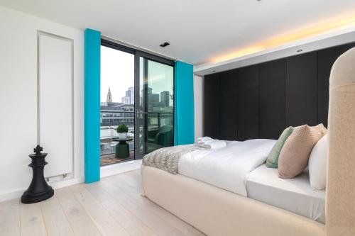 a bedroom with a large bed and a large window at City of London 2BR Penthouse with Stunning Terrace View & Air Condition in London