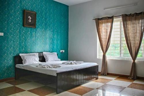 a bedroom with a bed with a blue wall at Comfort Nest in Coimbatore