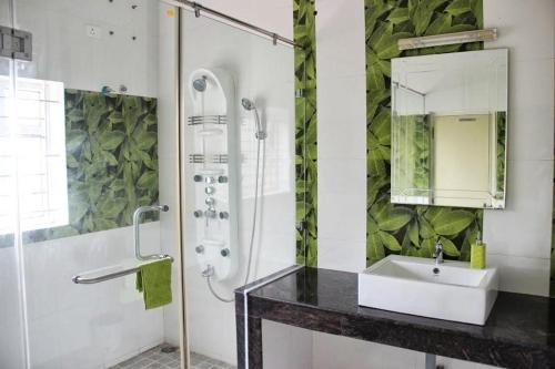 a bathroom with a sink and a shower with a mirror at Comfort Nest in Coimbatore