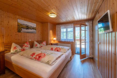 a bedroom with a bed in a room with wooden walls at Landhaus Barbara in Silbertal