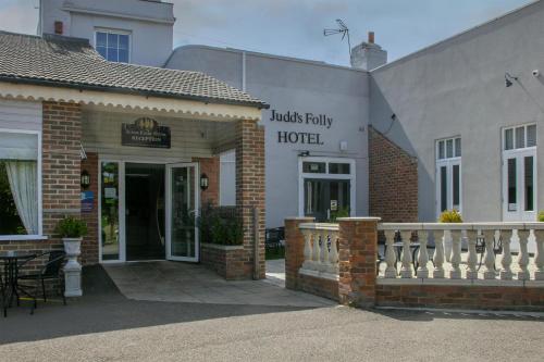 a hotel entrance to a building with a balcony at The Judds Folly Hotel, Sure Hotel Collection by Best Western in Faversham