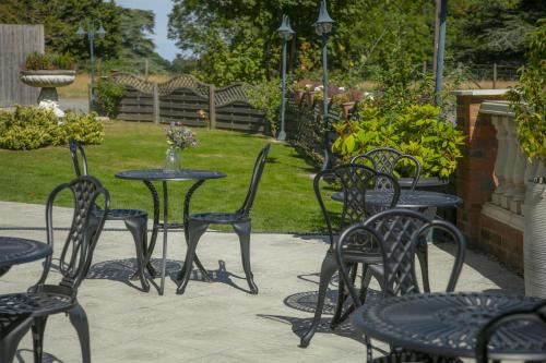 a group of tables and chairs in a yard at The Judds Folly Hotel, Sure Hotel Collection by Best Western in Faversham
