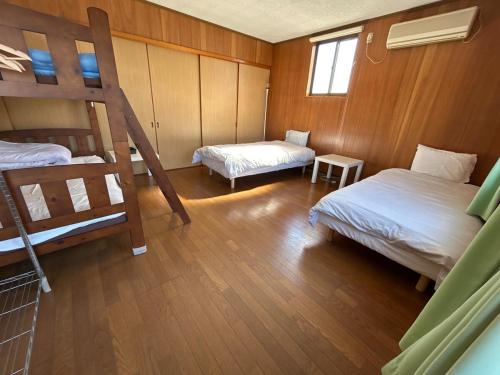 a room with two bunk beds and a table at VOYAGE Beautiful sunrise ocean view BEDROOM whole house, 2 rooms on 2nd floor, tatami room on 1st floor, &private garage in Hyuga