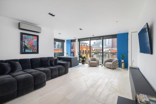 a living room with a large couch and chairs at City of London 2BR Penthouse with Stunning Terrace View & Air Condition in London
