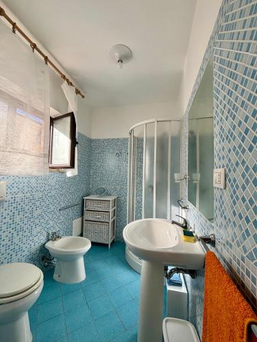 a blue bathroom with a toilet and a sink at Dimore Dell'Isola Rossa in Isola Rossa