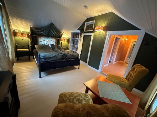 a bedroom with a bed and a table and chairs at Låven Parsellhage in Hoset