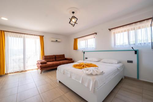 a bedroom with a bed and a couch and windows at Ankakyaka Apart Hotel in Muğla