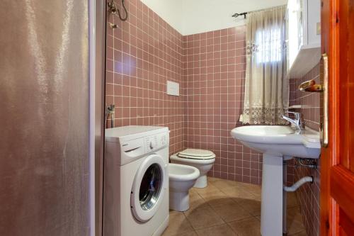 a bathroom with a washing machine and a sink at Verande Tanca Torre in Isola Rossa