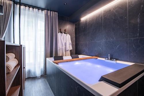 a bathroom with a large tub in a room at La Suite Bleue in Cholet