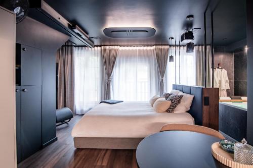 a bedroom with a bed and a large window at La Suite Bleue in Cholet