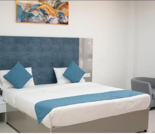 a bedroom with a bed with blue and white pillows at Gulf Star Hotel Hargeisa in Hargeysa