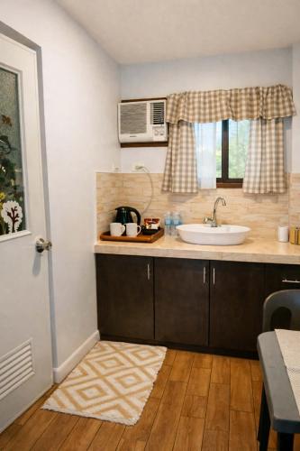 a kitchen with a sink and a microwave at Point Gate Inn in Bacolod