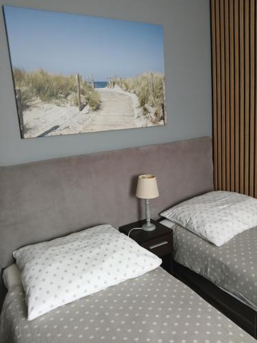 a bedroom with two beds and a picture of a beach at Noclegi nad Morzem u Kasi in Gdańsk