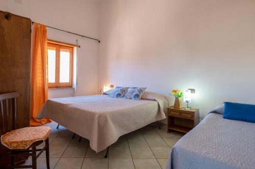 a bedroom with two beds and a window at Dimore Dell'Isola Rossa in Isola Rossa