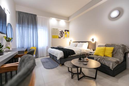 a hotel room with a bed and a couch at Breeze Apartments Megara - Linea in Megara