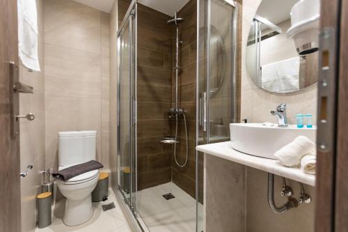 a bathroom with a shower and a toilet and a sink at Breeze Apartments Megara - Linea in Megara