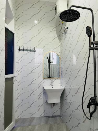 a white bathroom with a sink and a mirror at Triple E Lodge Kibaha in Kibaha