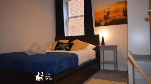 a bedroom with a bed with a dog laying on it at Charming 1-Bed with Private Parking & Full Bath in Dunstable
