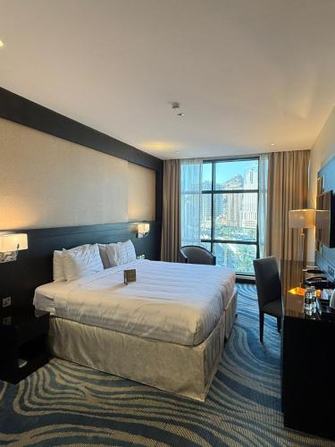 a hotel room with a bed and a large window at Elaf Al Sagryah Hotel in Mecca