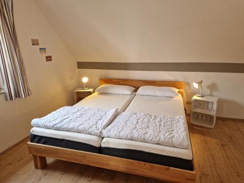 a bedroom with a large bed with two white pillows at Kajüte 4 in Lemkenhafen auf Fehmarn