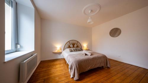 a bedroom with a bed with two pillows on it at Au petit détour Confort in Rolampont
