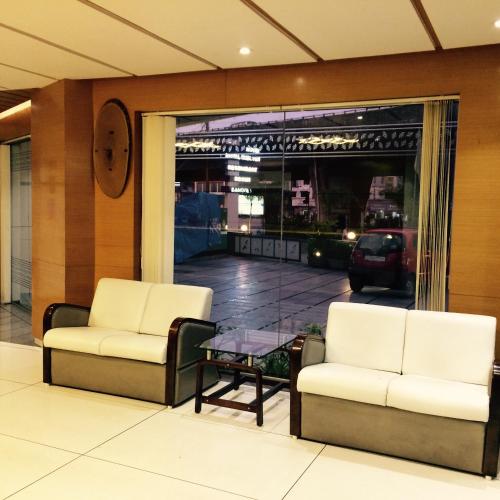 two chairs and a coffee table in a lobby at Hotel Royal Shelter in Vapi