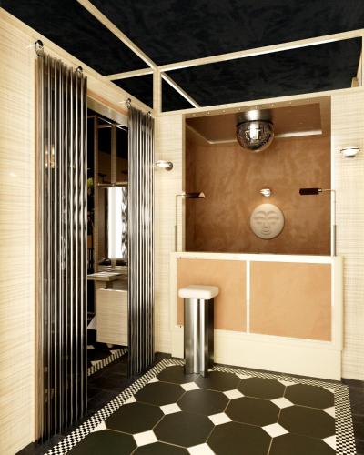 ein Badezimmer mit Dusche und Schachbrettboden in der Unterkunft Hôtel Luxia & Spa in Paris