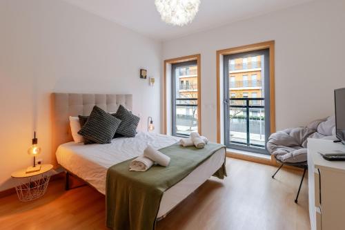 a bedroom with a bed with towels on a table at HolidaysPT 1 - Marina Village 2 bedroom apartment in Olhão