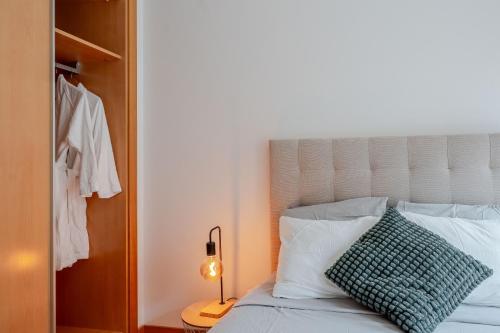 a bedroom with a bed with a green pillow on it at HolidaysPT 1 - Marina Village 2 bedroom apartment in Olhão