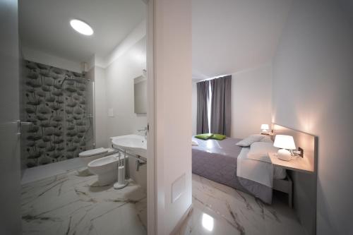 a bedroom with a bed and a bathroom with a sink at La Casa Di Nonna in Licusati