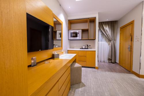 a kitchen with a large flat screen tv on the wall at Al Muahidb Residence Al Takhasossi 4 - Economic in Riyadh