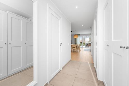 an empty hallway with white doors and a dining room at Metsa terraced house in Haapsalu