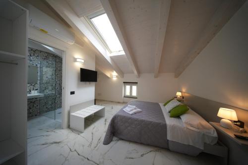 a bedroom with a bed and a bathroom with a skylight at La Casa Di Nonna in Licusati