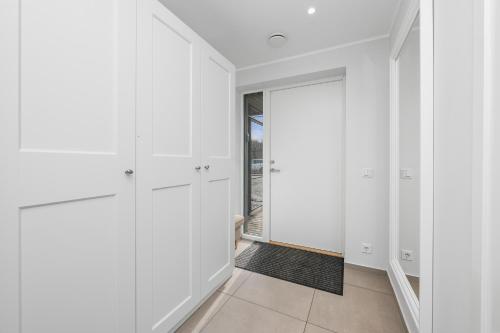 a bedroom with white cabinets and a door to a balcony at Metsa terraced house in Haapsalu