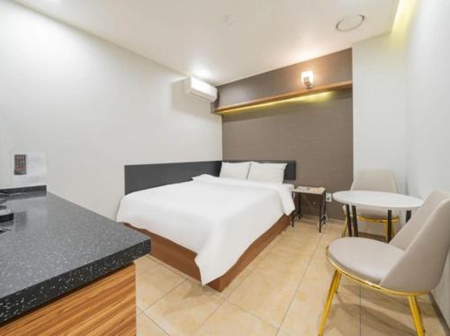 a bedroom with a bed and two tables and chairs at Motel Some in Suwon