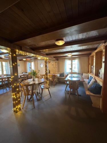 a living room with tables and chairs and a couch at Alpwirtschaft Heirihütte in Rigi Klösterli