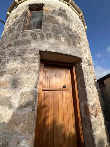 a wooden door in a stone tower at Petromilos1920 in Zefiría