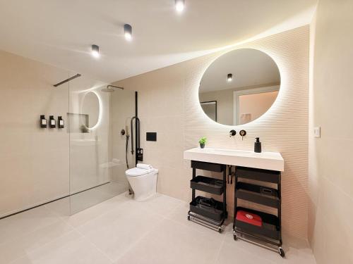 a bathroom with a sink and a toilet and a mirror at Suite 1 Premium, accesible y luminoso by VidaCalma in Valencia