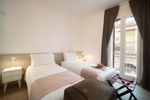 a hotel room with two beds and a window at Le Contrade Vico Alba in Monopoli