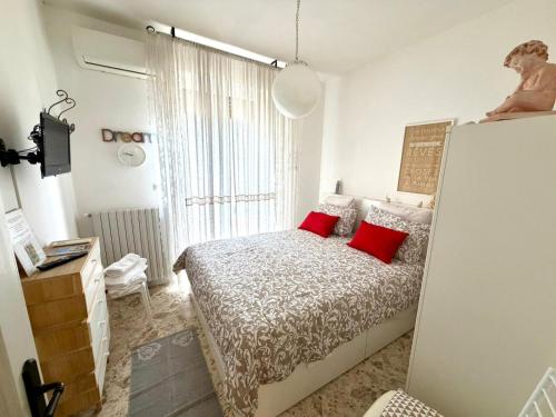 a bedroom with a bed with two red pillows at Almasol in Cassano delle Murge