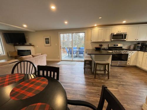 a kitchen and living room with a table and chairs at SKI Bike, Hike & Golf Townhouse w/ Hot tub in Ellicottville